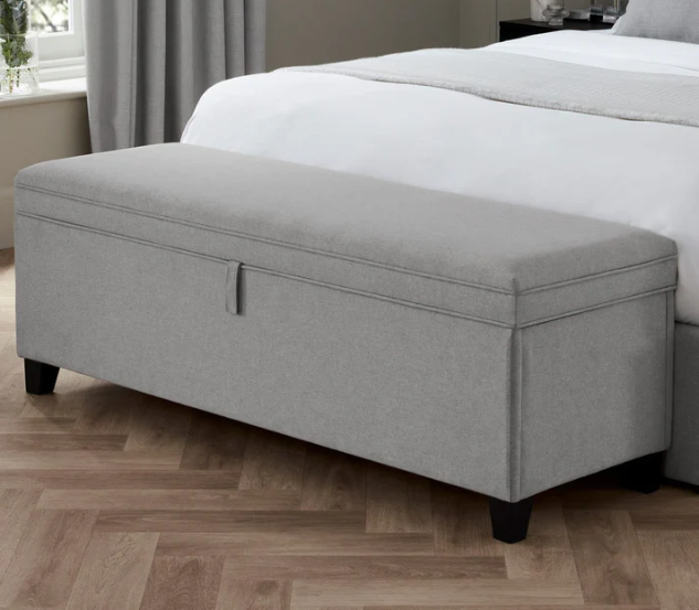 Bedside storage ottoman as a multifunctional piece of furniture.