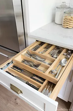 Wooden drawer organizer for small items like spoons. 