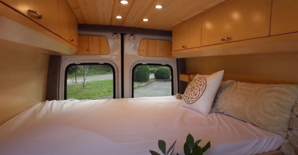 Overhead storage cabinets inside the sleeping space of the van.