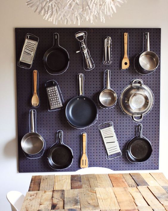 Pegboard displaying hanged kitchen utensils.