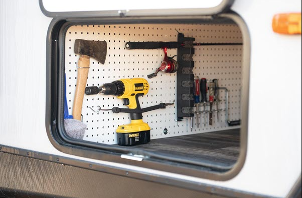 Pegboard with hooks and handles for tools storage. 