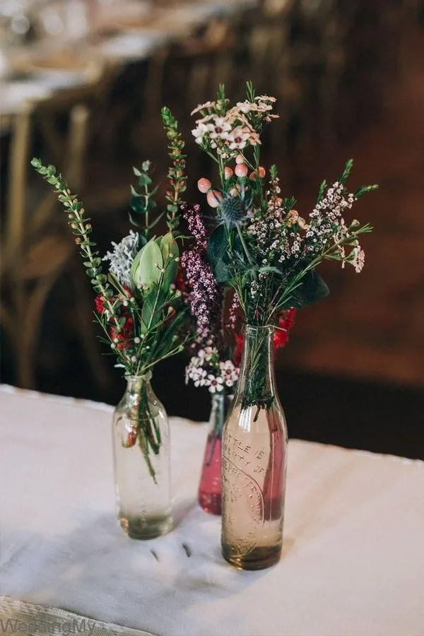 Prickly, tiny autumnal blooms in a trio of glass bottles.