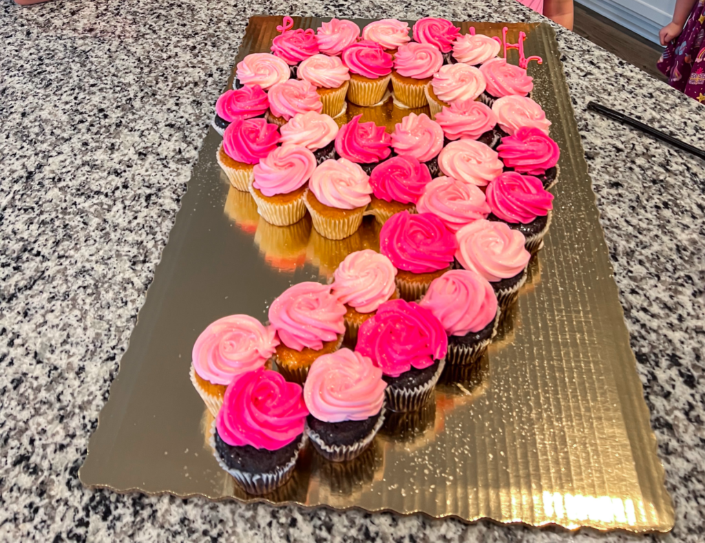 Cupcakes with different shades of pink frosting arranged as number 9.