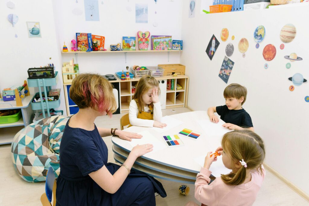 Children sitting around the table with a vibrant, colorful backdrop.