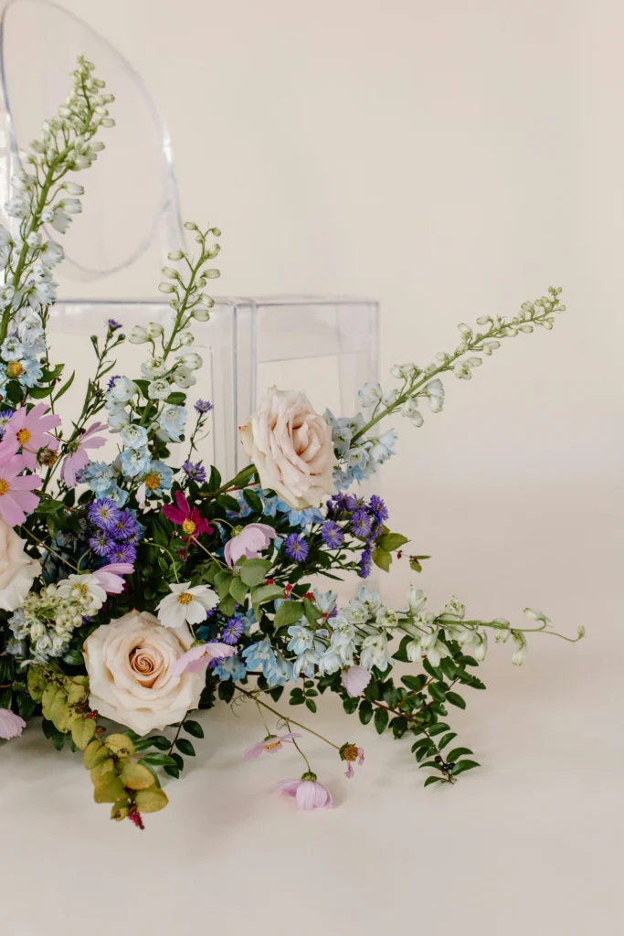 A transparent hollow cube acting as a terrarium for the display of wildflowers.