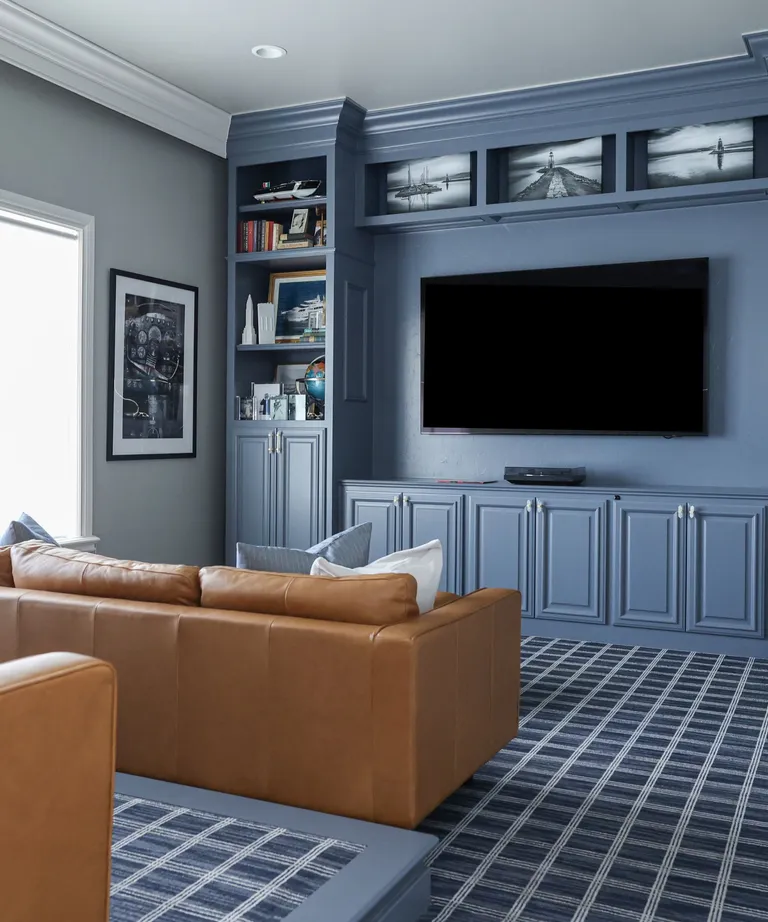 Cognac-coloured sectional sofa in a soft blue theatre room.
