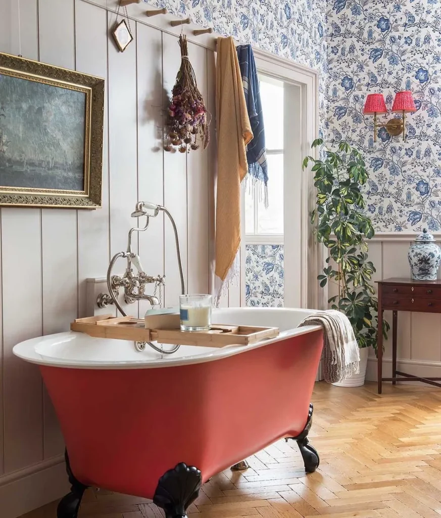 Pink clawfoot bathtub and a floral vintage wallpaper.